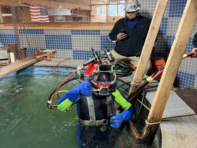 Franklin County Technical School senior Christian Hurd gives a thumbs-up inside the dive tank where he was able to practice underwater welding at the North Atlantic States Carpenters Training Fund facility in Millbury on March 19. 