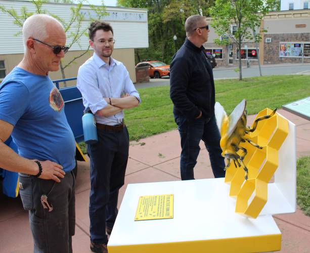 Artist Thor Holbek, at left, stands in front of the beehive sculpture on Bank Row in Greenfield that he restored after it was vandalized. Next to Holbek is Greenfield’s Economic and Community Development Assistant Christian LaPlante.