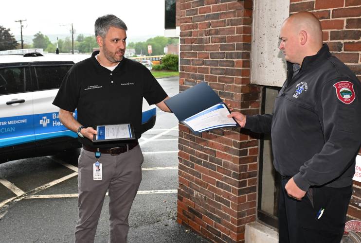 Baystate Health physician and Associate Regional EMS Medical Director Dr. Matthew Shapiro, left, gives a Clinical Excellence Award recognizing lifesaving efforts by South County EMS paramedic Adam Martin in a ceremony at Baystate Franklin Medical Center on Thursday.