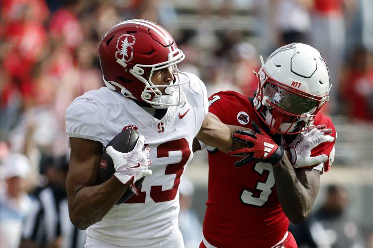 Stanford wide receiver Elic Ayomanor (13) stiff-arms North Carolina State cornerback Aydan White (3) after receiving a pass in Raleigh, N.C., Nov. 2, 2024. 