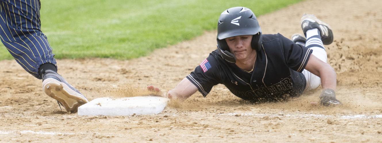 Pioneer's Alex McClelland slides back to first base during the PVIAC Class D championship game against Hopkins Academy at Mackenzie Stadium, Wednesday, May 28, 2025, in Holyoke.