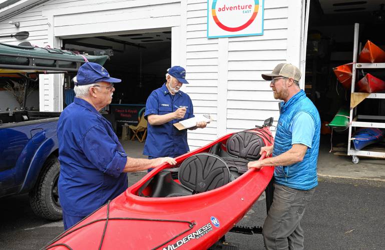 William Bell and Tom Fydenkevez of the U.S. Coast Guard Auxiliary inspect a tandem kayak on Monday morning with Brian Pearson, owner of Adventure East, in Sunderland. 