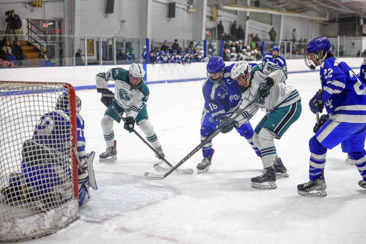 Greenfield’s Shawn Baumann (7) and Luca Siano (21) fight for the puck against West Springfield’s Cole Castor (16) in the first period Wednesday at Collins-Moylan Arena in Greenfield.