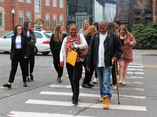 Elvio J. Marrero crosses Main Street in Greenfield with his sister and members of the Boston College Innocence Program to test out his GPS monitoring device on Tuesday after posting $5,000 bail in Franklin County Superior Court. He has been in prison for a 1994 murder but the state Supreme Judicial Court on Jan. 11 ordered a new trial.