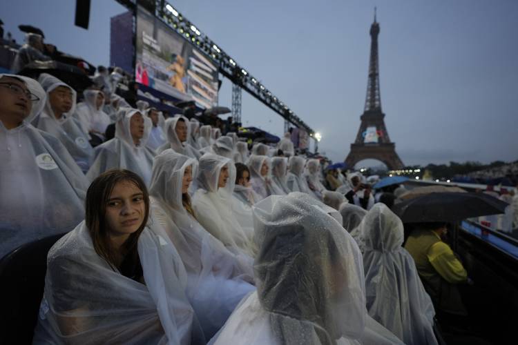 Spectators in the rain in Paris, France, during the opening ceremony of the 2024 Summer Olympics, Friday, July 26, 2024. (AP Photo/Robert F. Bukaty)