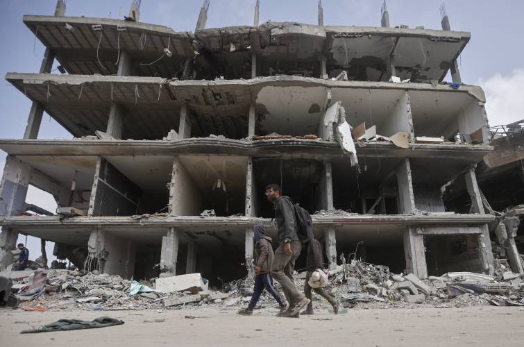 Palestinians walk through destruction after Israeli forces left Khan Younis, Gaza Strip, Wednesday, March 6, 2024. Palestinians walk through destruction after Israeli forces left Khan Younis, Gaza Strip, Wednesday, March 6, 2024.