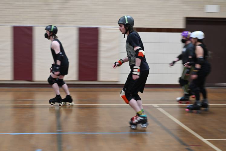 Members of the Pioneer Valley Roller Derby warm up skating around the perimeter of the gymnasium at Franklin Countys YMCA in Greenfield. 