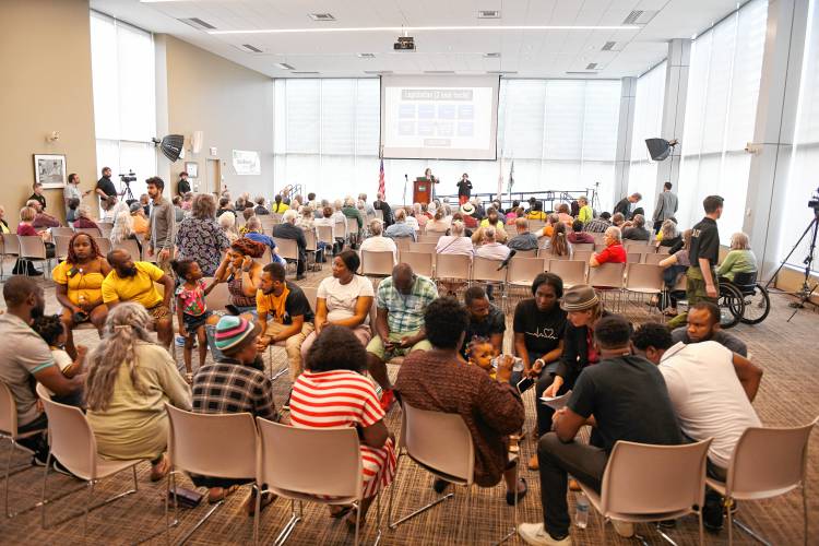 Attendees listen to a Haitian Creole interpreter at state Sen. Jo Comerford’s People’s Town Hall at Greenfield Community College on Monday.