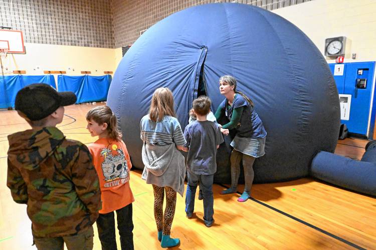 Llama Maynard, founder of Haydenville-based Stars Above, a traveling planetarium program serving Hampshire, Franklin and Berkshire counties, lets Colrain Central School students into the inflatable planetarium.