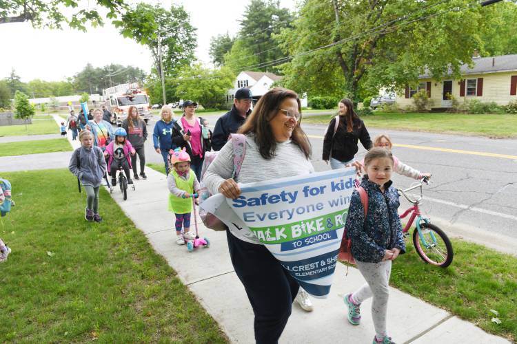 Parents and students make their way down Montague Street during the annual Walk, Bike & Roll Event for students at Sheffield and Hillcrest Elementary schools on Wednesday morning, with an escort from the Turners Falls Fire and Montague Police departments. The event is supported by the Massachusetts Safe Routes to School program.