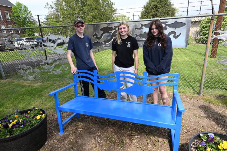 Franklin County Technical School students Brandon Janik, Jenna Petrowicz and Lilliana Lonergan with the bench and fish silhouettes they created for the courtyard at the Turners Falls Fishway near the dam.