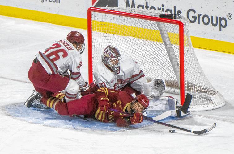 UMass defenseman Owen Murray, left, and Boston College forward Teddy Stiga, bottom, skate into UMass goalie Michael Hrabal, top, during the college hockey game at the Mullins Center, Saturday, Feb. 15, 2025, in Amherst.