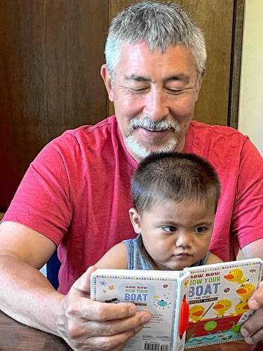 The Rev. James Koyama, pictured here reading a book to his grandson, is the pastor at the First Congregational Church of Montague. The Rev. James Koyama, pictured here reading a book to his grandson, is the pastor at the First Congregational Church of Montague.