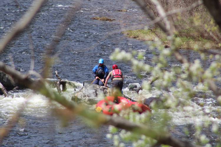 Crews work to recover a raft that got stuck on a log in the Deerfield River in Charlemont on Friday morning.