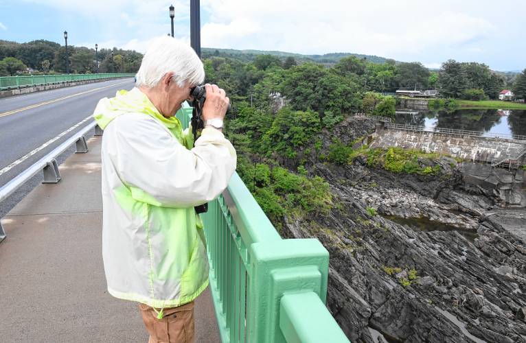 Local environmental activist Karl Meyer watches a shortnose sturgeon in a small pool of water below the Turners Falls dam on Wednesday evening. Research Fishery Biologist Micah Kieffer with the U.S. Geological Survey captured and processed the fish. It was later released.