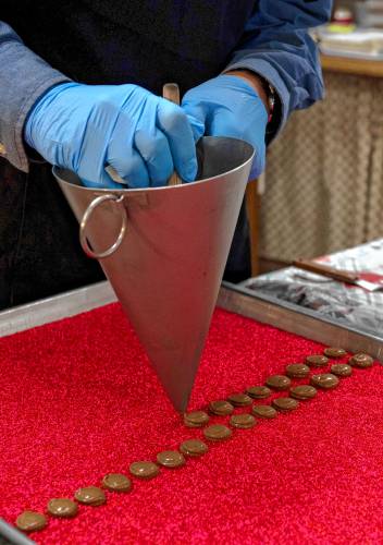 Christopher Owen, an employee at Richardson’s Candy Kitchen in Deerfield, makes nonpareils in preparation for Valentine’s Day.