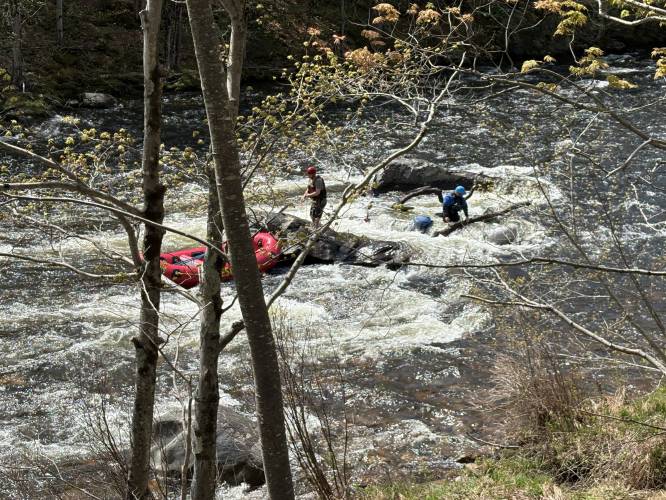 Crews work to recover a raft that got stuck on a log in the Deerfield River in Charlemont on Friday morning.