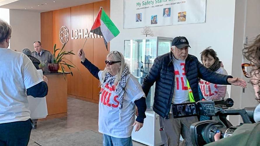 Priscilla Lynch, left, and Nick Mottern of the activist group Demilitarize Western Mass stand inside the lobby of the L3Harris building in Northampton before being arrested on charges of trespassing and disturbing the peace on Wednesday.