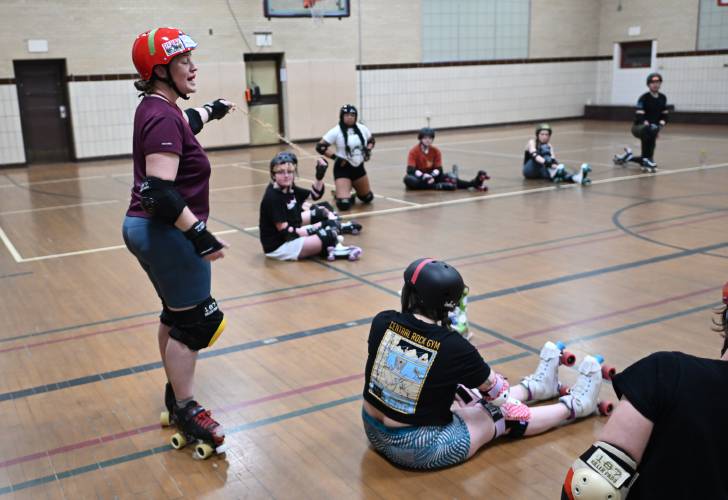 Caroline âBash-It Houndâ Moore of Northampton holds up a ten foot rope to demonstrate spacing to  participants of the Pioneer Valley Roller Derby at Franklin Countys YMCA in Greenfield. 