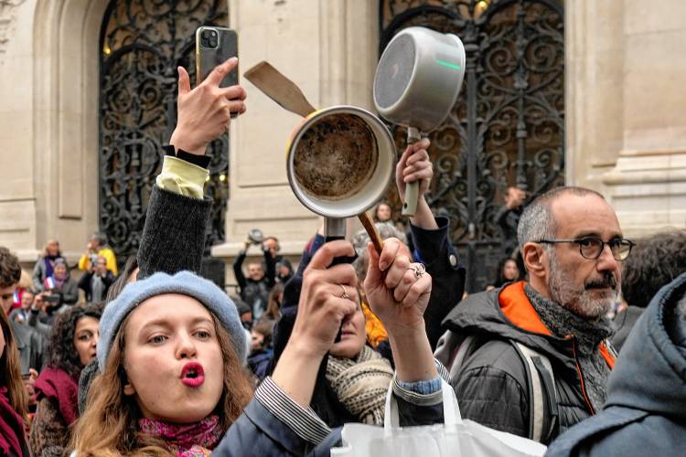 People bang pots and pans in Paris while French President Emmanuel Macron speaks to the nation on April 17, 2023, a time-honored means of protest.