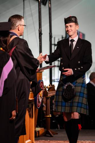 Northfield Mount Hermon School Head of School Brian Hargrove shakes hands with graduate Quinn Bathory-Peeler while distributing diplomas at Sunday’s commencement ceremony.