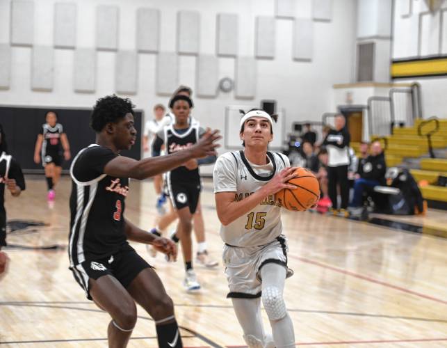 Pioneer's Alex McClelland drives to the rim while defended by Libertas Academy's Sa'ad Maigari during a quarterfinal contest of the Western Mass. Class D Tournament at Messer Gymnasium Monday. 