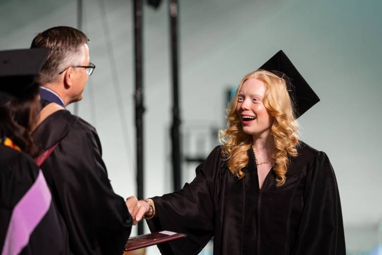 Northfield Mount Hermon School Head of School Brian Hargrove shakes hands with graduate Grace Bird while distributing diplomas at Sunday’s commencement ceremony.