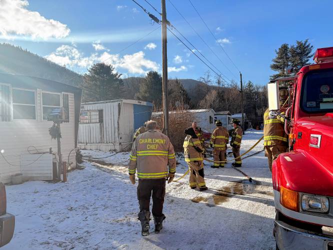 Charlemont, Shelburne Falls and Colrain firefighters work to extinguish a mobile home fire on Zoar Road in Charlemont Wednesday morning.