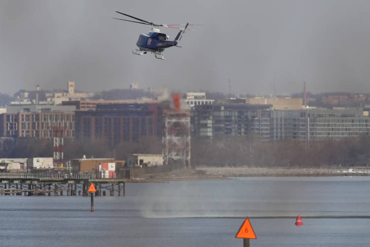 US Park Police helicopter during search and rescue efforts around a wreckage site in the Potomac River from Ronald Reagan Washington National Airport, early Thursday morning, Jan. 30, 2025, in Arlington, Va. (AP Photo/Carolyn Kaster)