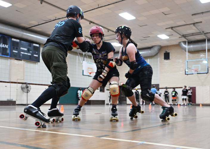 Members of the Pioneer Valley Roller Derby practice blocking and checking techniques at Franklin Countys YMCA in Greenfield. 