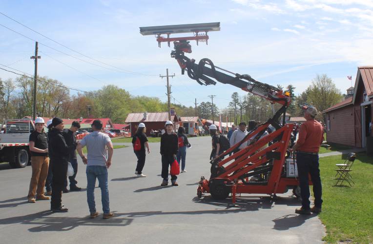 Employees with R&R Window Contractors of Easthampton demonstrate a piece of equipment for students at the third Construction & Trades Careers Day at the Franklin County Fairgrounds earlier this month.
