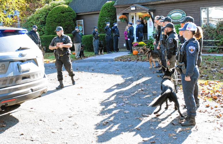 Montague Police Officer James Ruddock walks out of the Pioneer Valley Veterinary Hospital in Greenfield on Tuesday with the cremated remains and collar of his K-9, Artie, who was euthanized on Oct. 2.