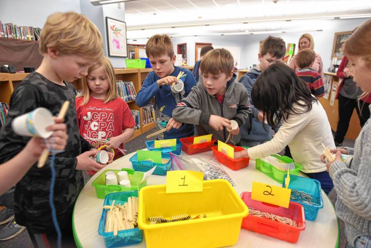 Second grade students gather art supplies to make imaginary candy at the Willy Wonka workshop in the Conway Grammar School library on Tuesday for a celebration of Read Across America Day.