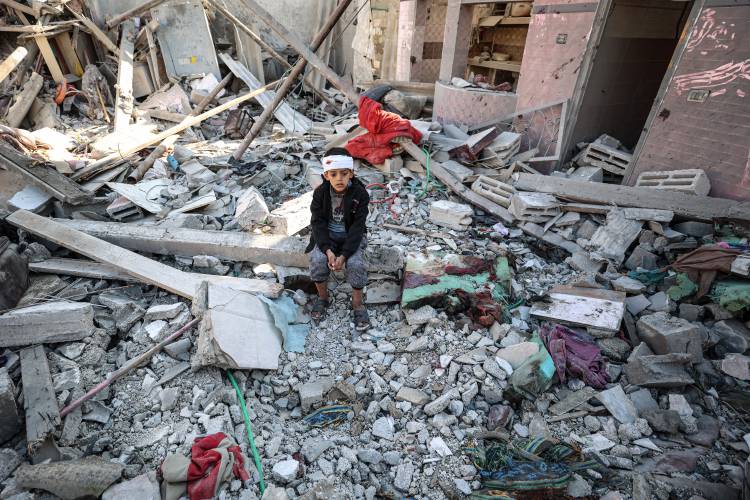  An injured Palestinian child sits on the rubble of the destroyed building after the Israeli bombing of Rafah in the southern Gaza Strip, on January 18, 2024.