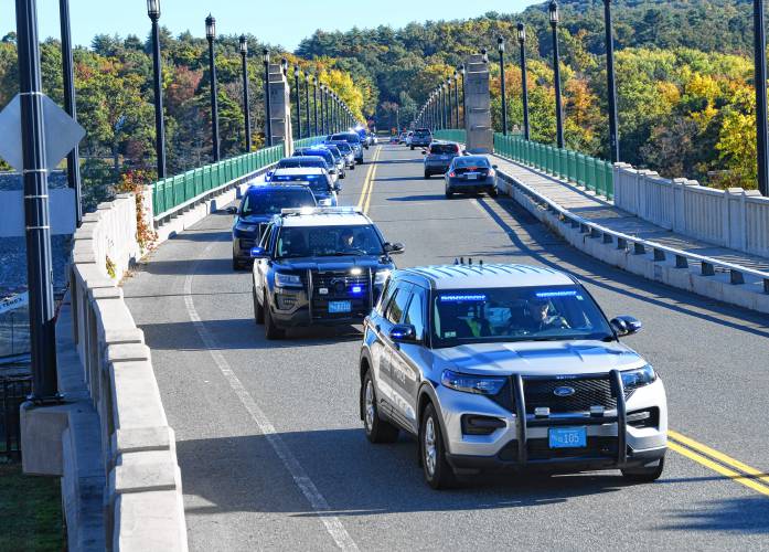 Vehicles pull over on the Turners Falls-Gill Bridge as Montague Police Officer James Ruddock and the cremated remains of his K-9, Artie, return to Montague after a police motorcade escorted him from the Pioneer Valley Veterinary Hospital in Greenfield to the Montague Public Safety Complex on Tuesday morning. 