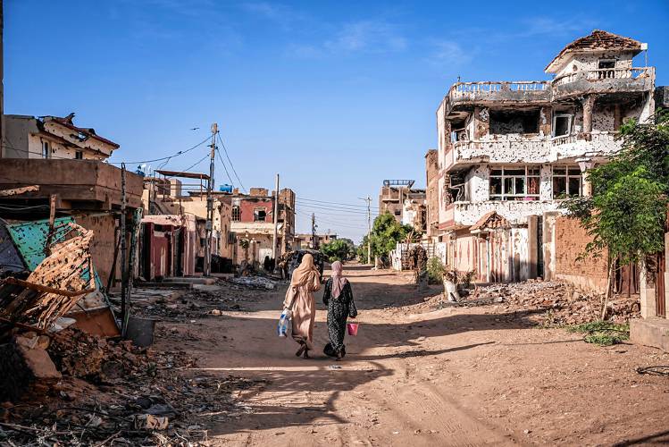 Women walk through a war-torn neighborhood in Omdurman, Sudan, in November. Women walk through a war-torn neighborhood in Omdurman, Sudan, in November.