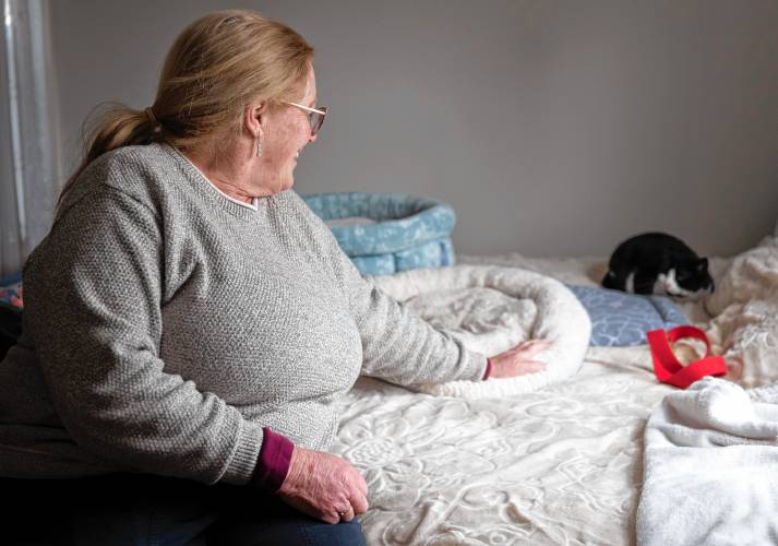 Beth Malloy with Elsa on her bed at their home in South Deerfield.