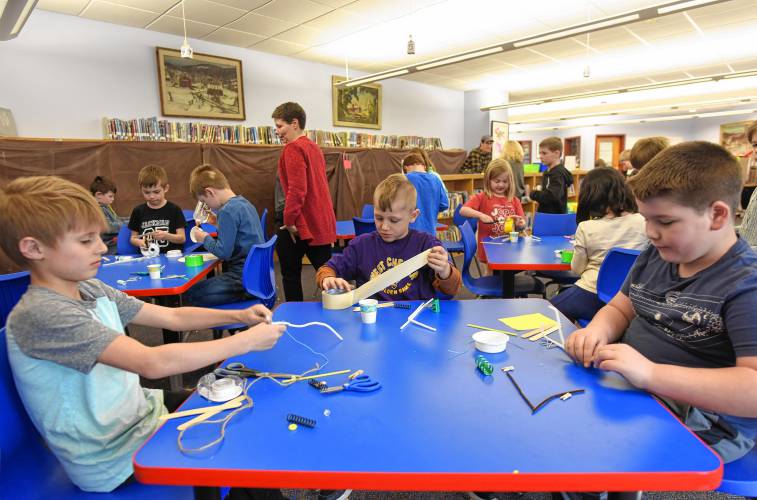 Second grade students Lucas Potter, Eliot Jackman and TJ Boyle make imaginary candy on Tuesday at the Willy Wonka workshop in the Conway Grammar School library in celebration of Read Across America Day.