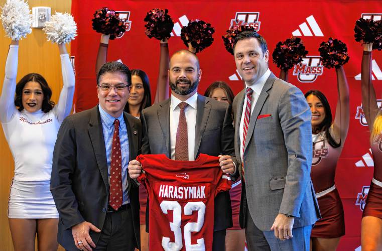 Joe Harasymiak, center, poses as the new UMass head football coach with Chancellor Javier Reyes, left, and Athletics Director Ryan Bamford on Dec. 7. Joe Harasymiak, center, poses as the new UMass head football coach with Chancellor Javier Reyes, left, and Athletics Director Ryan Bamford on Dec. 7.