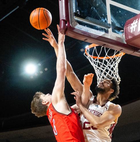 UMass forward Malek Abdelgowad, right, blocks a shot from Davidson forward Joe Hurlburt, left, during the college basketball game at the Mullins Center, Wednesday, Feb. 12, 2025, in Amherst.