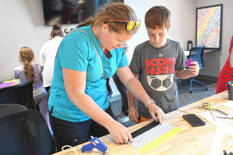 Katherine Sykes and her son Cody Osciak, 10, of Northfield, make a Pride flag at the Makerspace at the Greenfield Public Library on Tuesday.