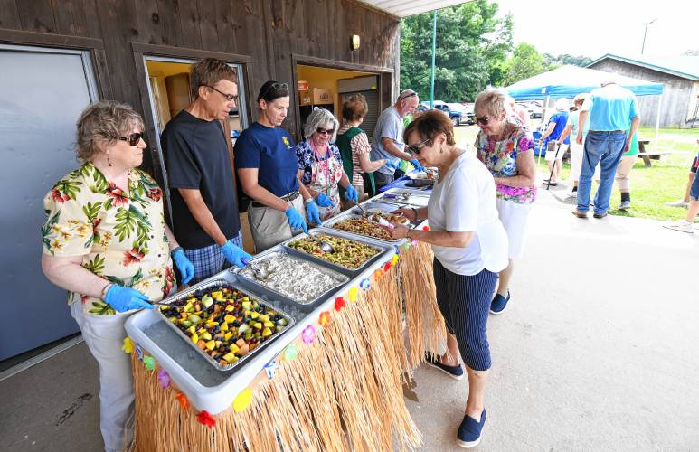 With assistance in cooking and serving from the Franklin County Sheriff’s Office, people line up for lunch at the South County Senior Center’s annual picnic at Herlihy Park in Whately on Wednesday.