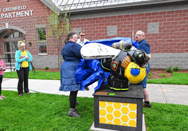 Sculptor Rachel Katz and painter Andrew Easton, with Mayor Ginny Desorgher and Fire Chief Robert Strahan in back,  reveal the city’s newest bee sculpture in front of the new Greenfield Fire Station. The statue is called Fearless and is complete in turn out gear. 
