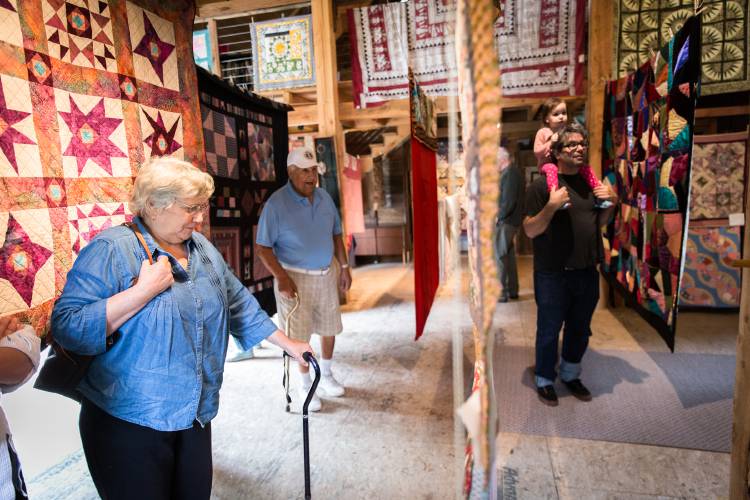 Attendees of the 2017 “Summer Day on the Buckland Common” event tour a barn filled with quilts. The event returns for the eighth year on Saturday, July 20.