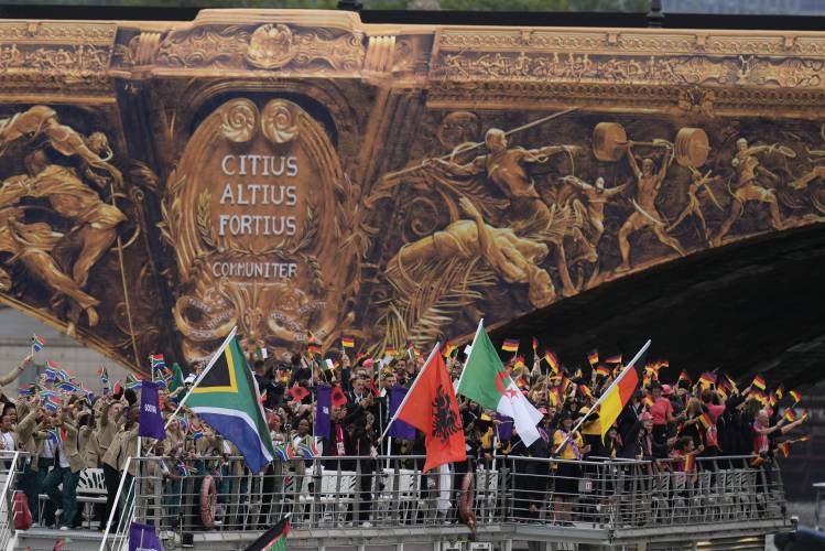South Africa, left, and other countries move on a boat along the Seine River in Paris, France, during the opening ceremony of the 2024 Summer Olympics, Friday, July 26, 2024. (AP Photo/Kirsty Wigglesworth)
