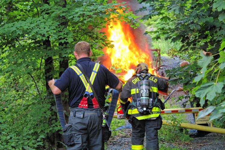 Greenfield firefighters work to extinguish a flaming vehicle at 303 Hope St. on Tuesday afternoon.