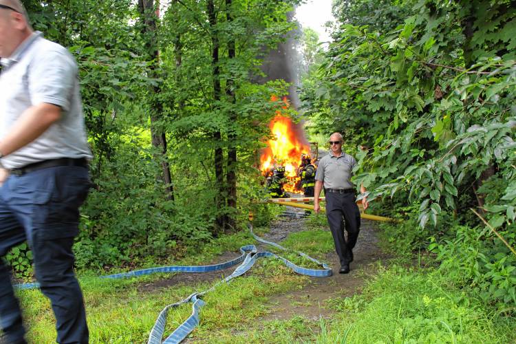 Greenfield firefighters work to extinguish a flaming vehicle at 303 Hope St. on Tuesday afternoon.