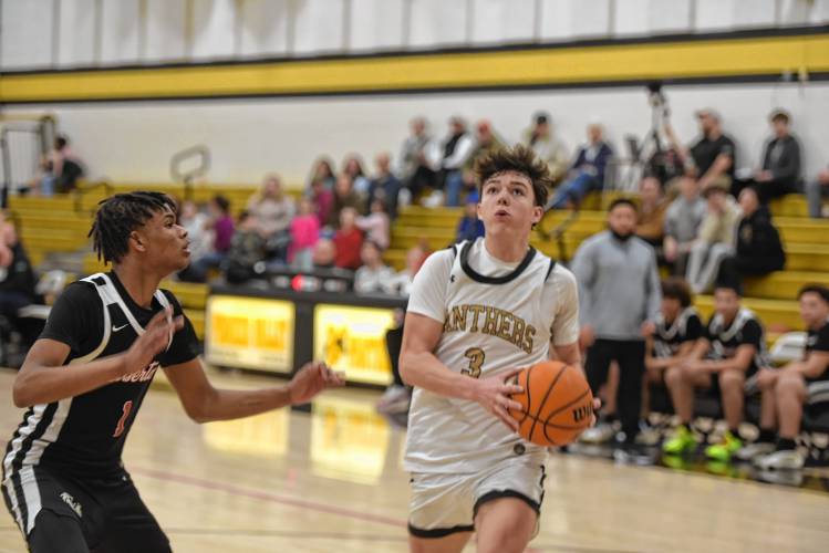 Pioneer's Kurt Redeker drives to the basket while guarded by Libertas Academy's Ron Jones during a quarterfinal contest of the Western Mass. Class D Tournament at Messer Gymnasium Monday. 