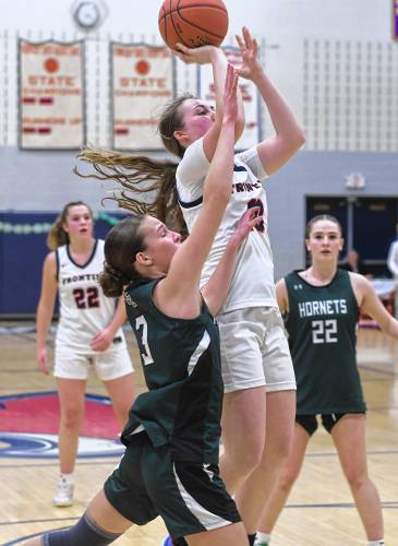 Frontier’s Skyler Steele shoot over Manchester Essex defender Lily Oliver during the Redhawks’ MIAA Division 4 Round of 32 victory at Goodnow Gymnasium in South Deerfield Thursday.