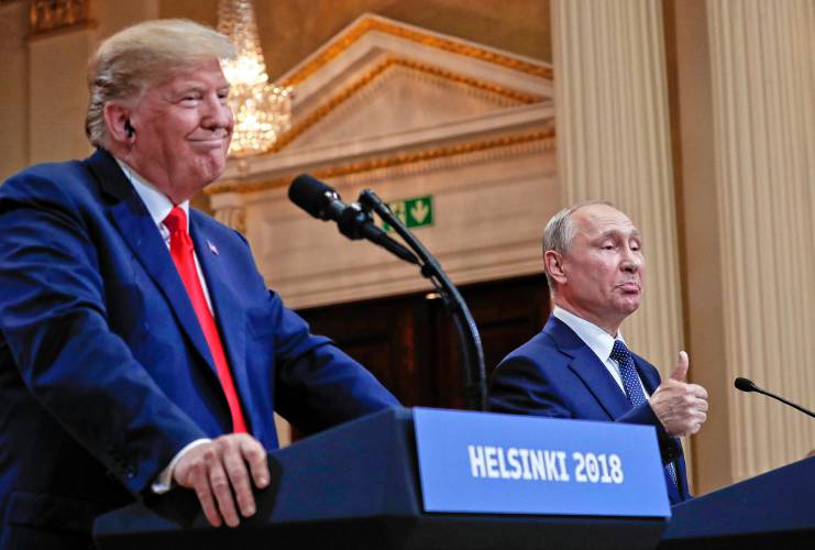 Russian President Vladimir Putin gestures as U.S. President Donald Trump looks on during their joint news conference at the Presidential Palace in Helsinki, Finland, in July 2018.